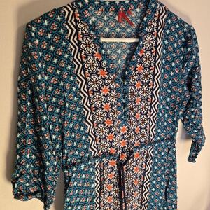 The vibrant orange and cool blues create a striking contrast in this blouse.